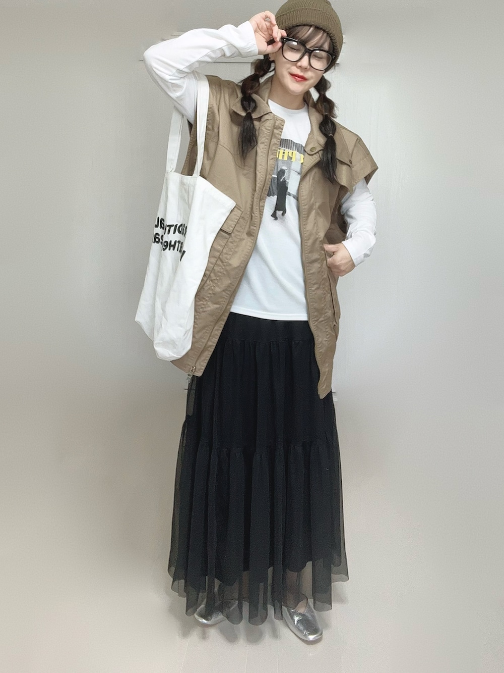 ブラック系のスカート、ホワイト系のTシャツ/カットソー、ベージュ系のジャケット/アウターを着用したレディースの秋コーディネートの3枚目の写真