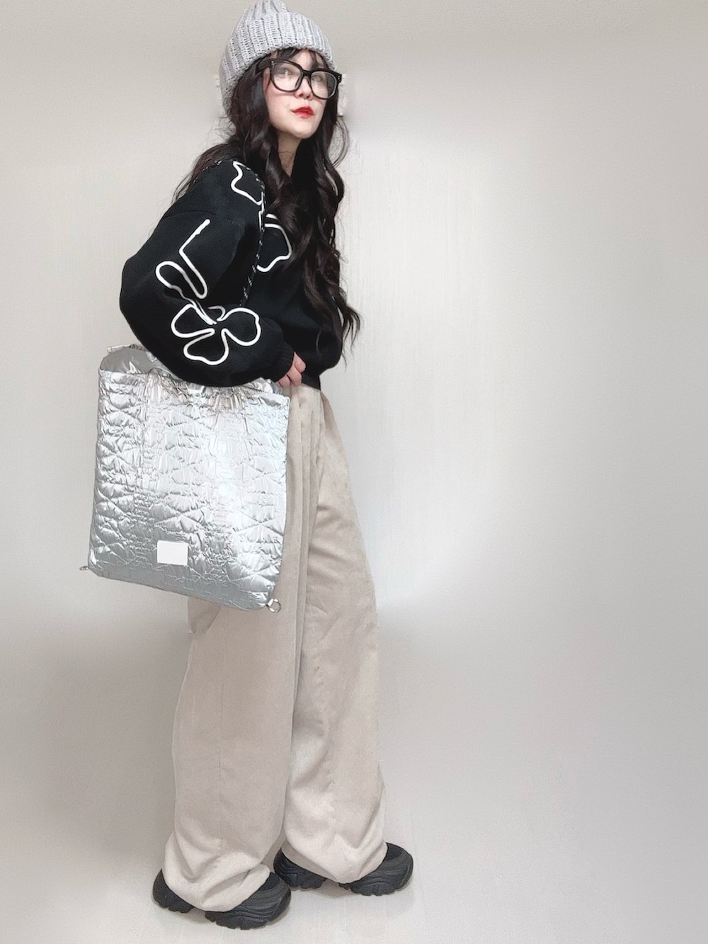 ブラック系のニット/セーター、シルバー系のトートバッグ、ベージュ系のスラックスを着用したレディースの冬コーディネートの4枚目の写真