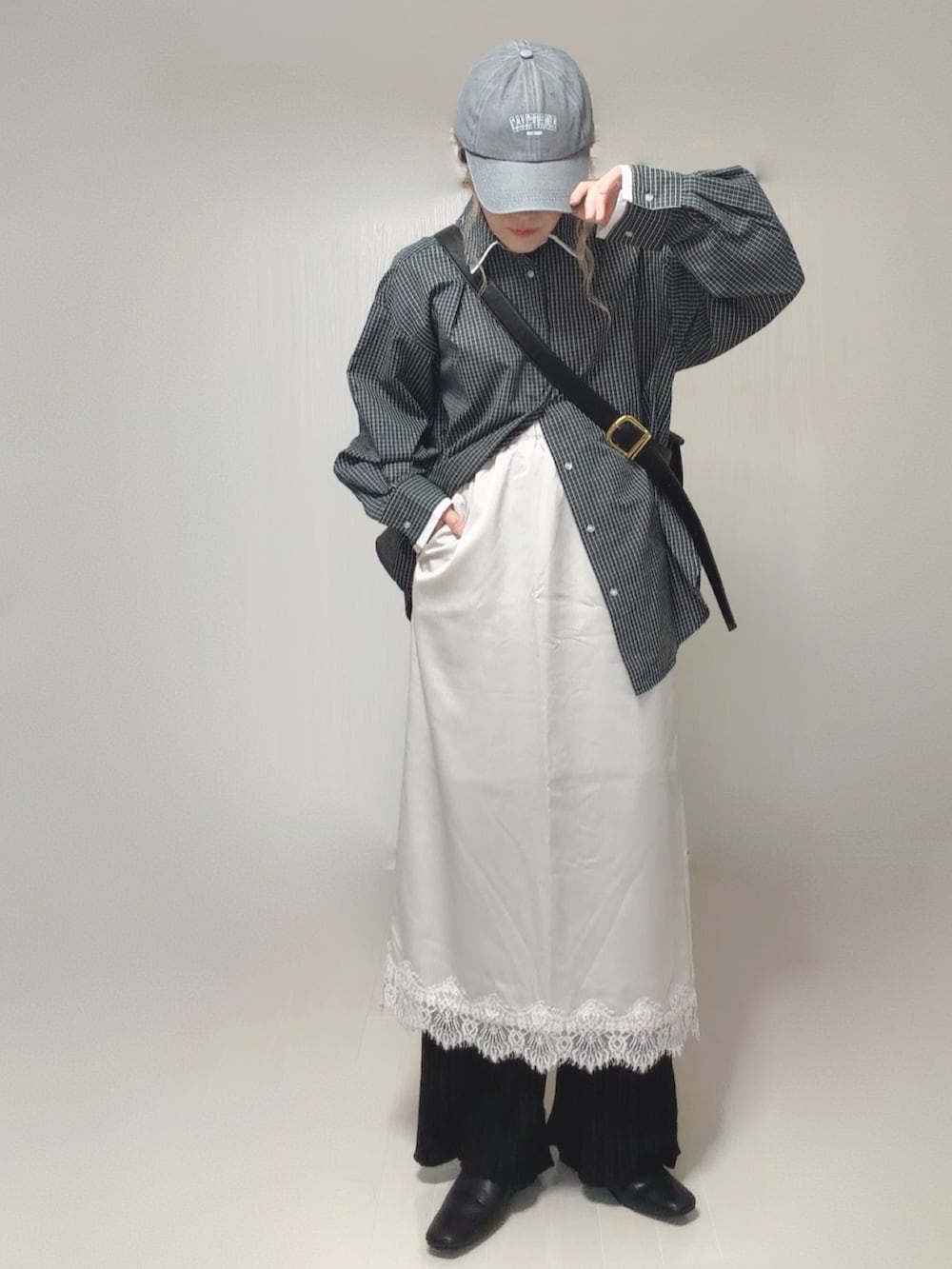 ブラック系のスリッポン、ホワイト系のスカート、ブラック系のその他パンツを着用したレディースの夏コーディネートの2枚目の写真
