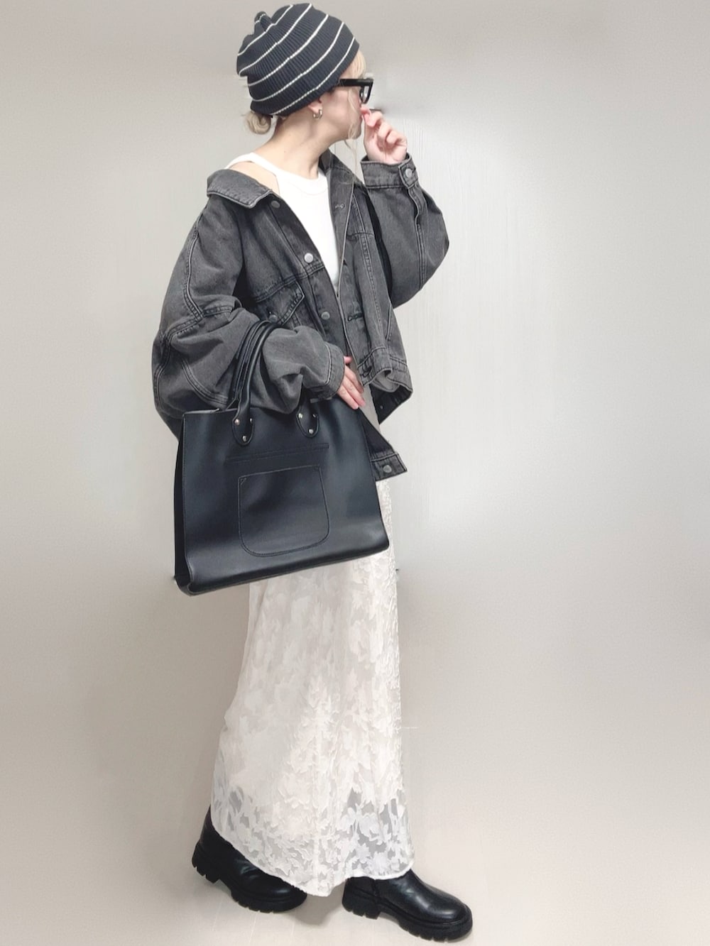 ホワイト系のタンクトップ、ブラック系のデニムジャケット、ブラック系のトートバッグを着用したレディースの秋コーディネートの2枚目の写真