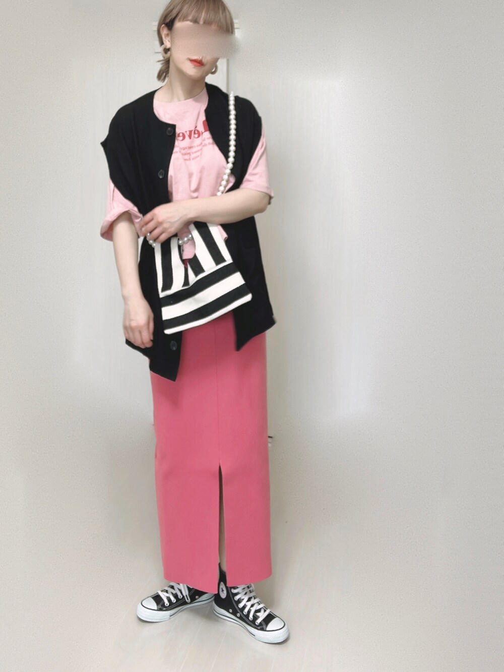 ブラック系のベスト、ホワイト系のショルダーバッグ、ピンク系のスカートを着用したレディースの夏コーディネートの3枚目の写真