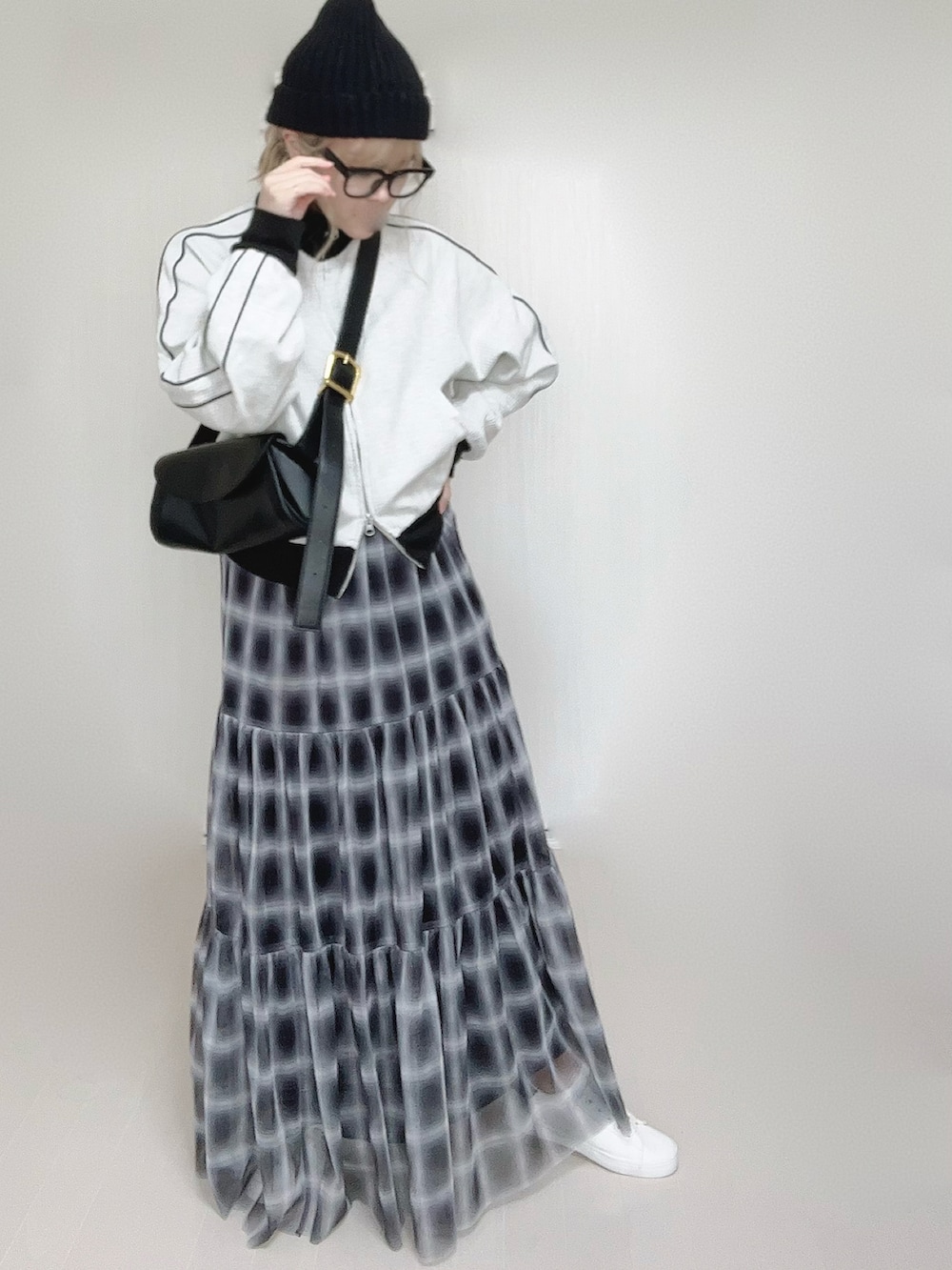 ブラック系のスカート、ベージュ系のジャージ、ホワイト系のスニーカーを着用したレディースの秋コーディネートの2枚目の写真