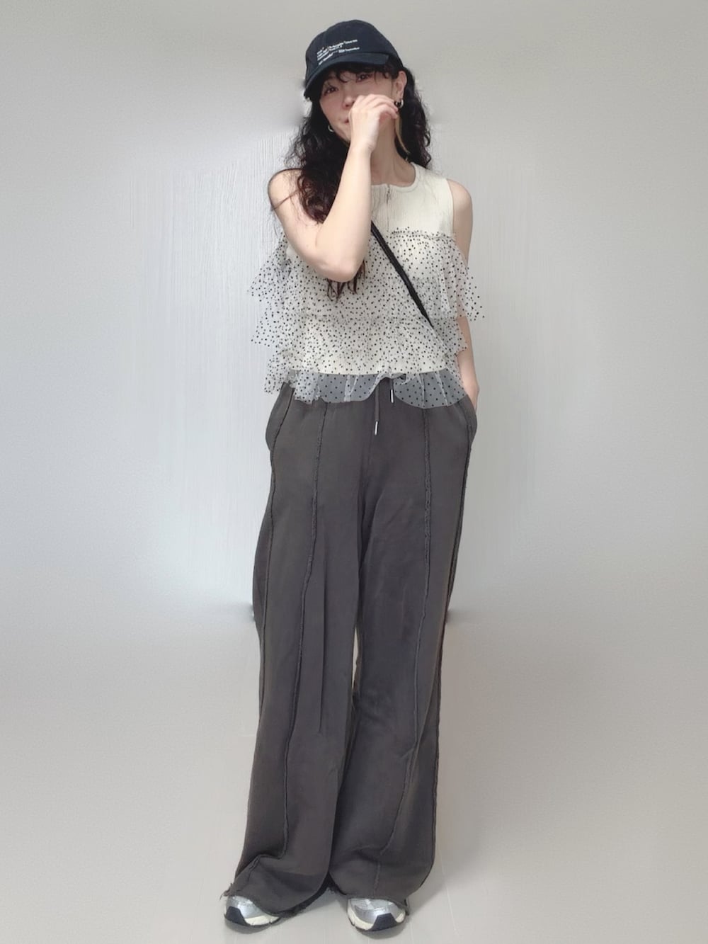 ホワイト系のニット/セーター、ブラック系のスウェットパンツ、ブラック系のボストンバッグを着用したレディースの夏コーディネートの4枚目の写真