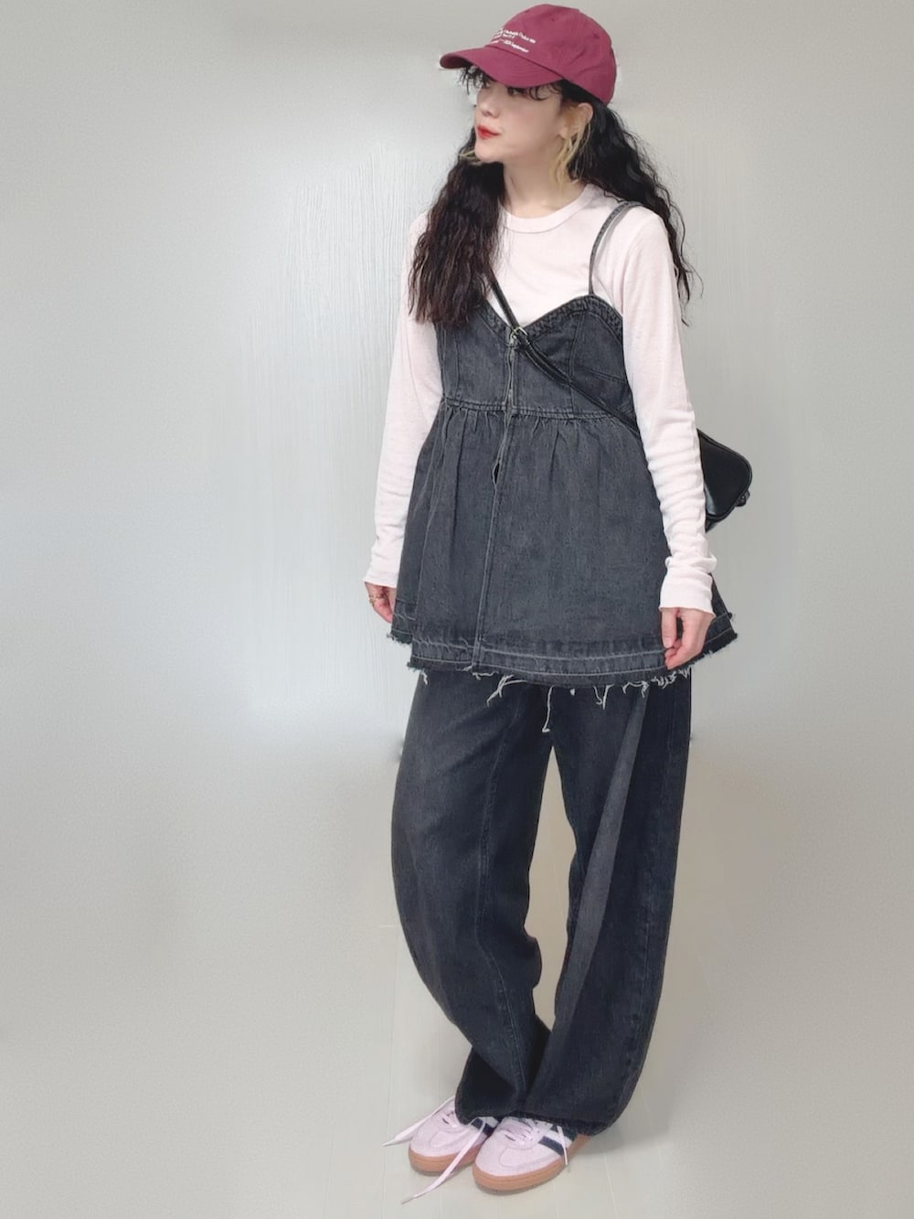 ブラック系のデニムパンツ、ブラック系のボストンバッグ、ピンク系のスニーカーを着用したレディースの春コーディネートの4枚目の写真