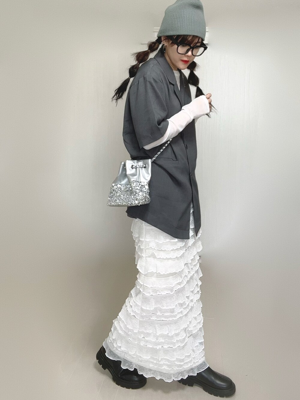 グレー系のテーラードジャケット、ブラック系のブーツ、ホワイト系のTシャツ/カットソーを着用したレディースの秋コーディネートの4枚目の写真