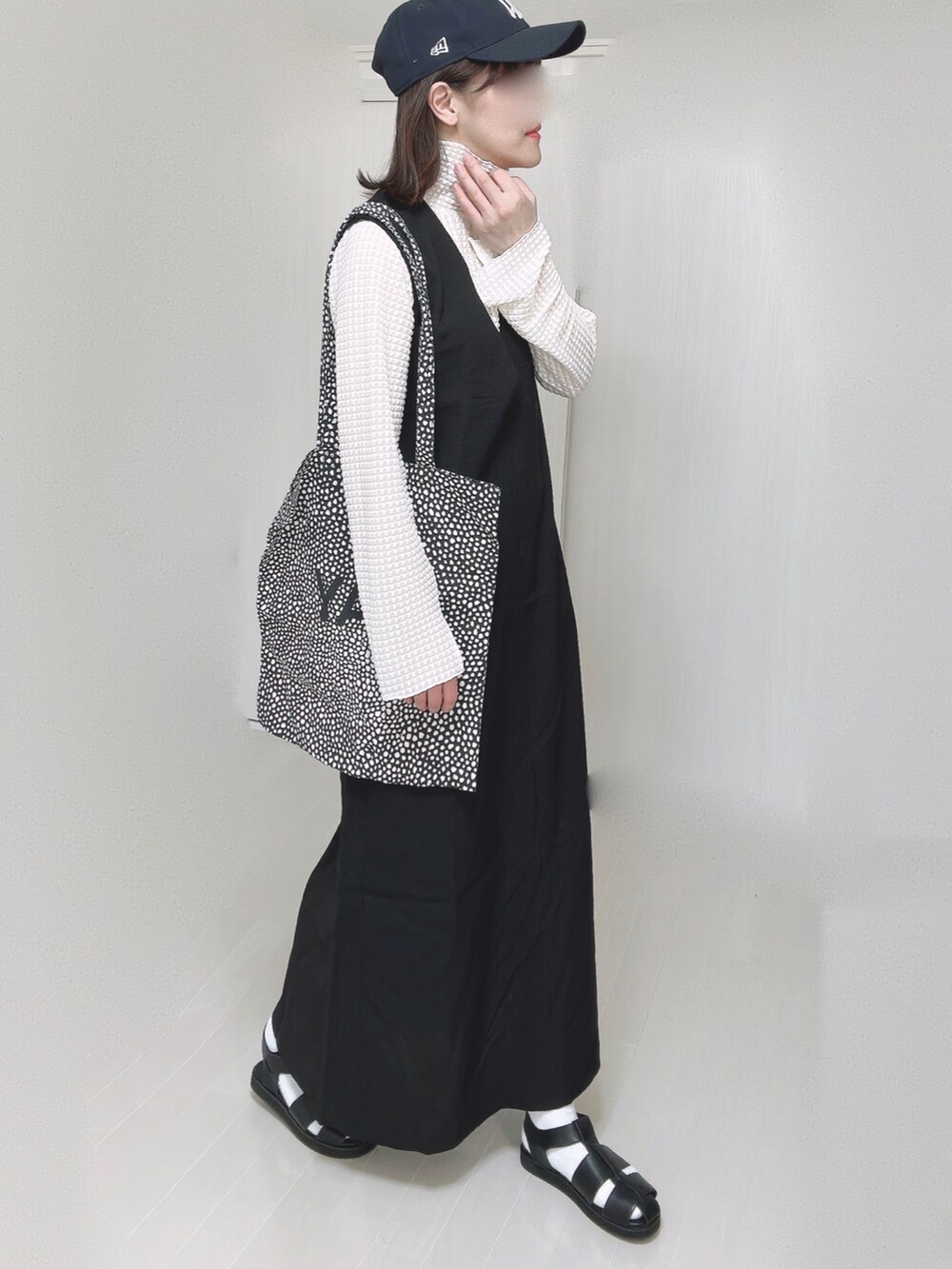 ホワイト系のTシャツ/カットソー、ブラック系のワンピース、ブラック系のサンダルを着用したレディースの春コーディネートの4枚目の写真