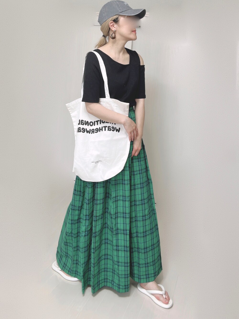 ブラック系のTシャツ/カットソー、ホワイト系のトートバッグ、グリーン系のスカートを着用したレディースの夏コーディネートの5枚目の写真