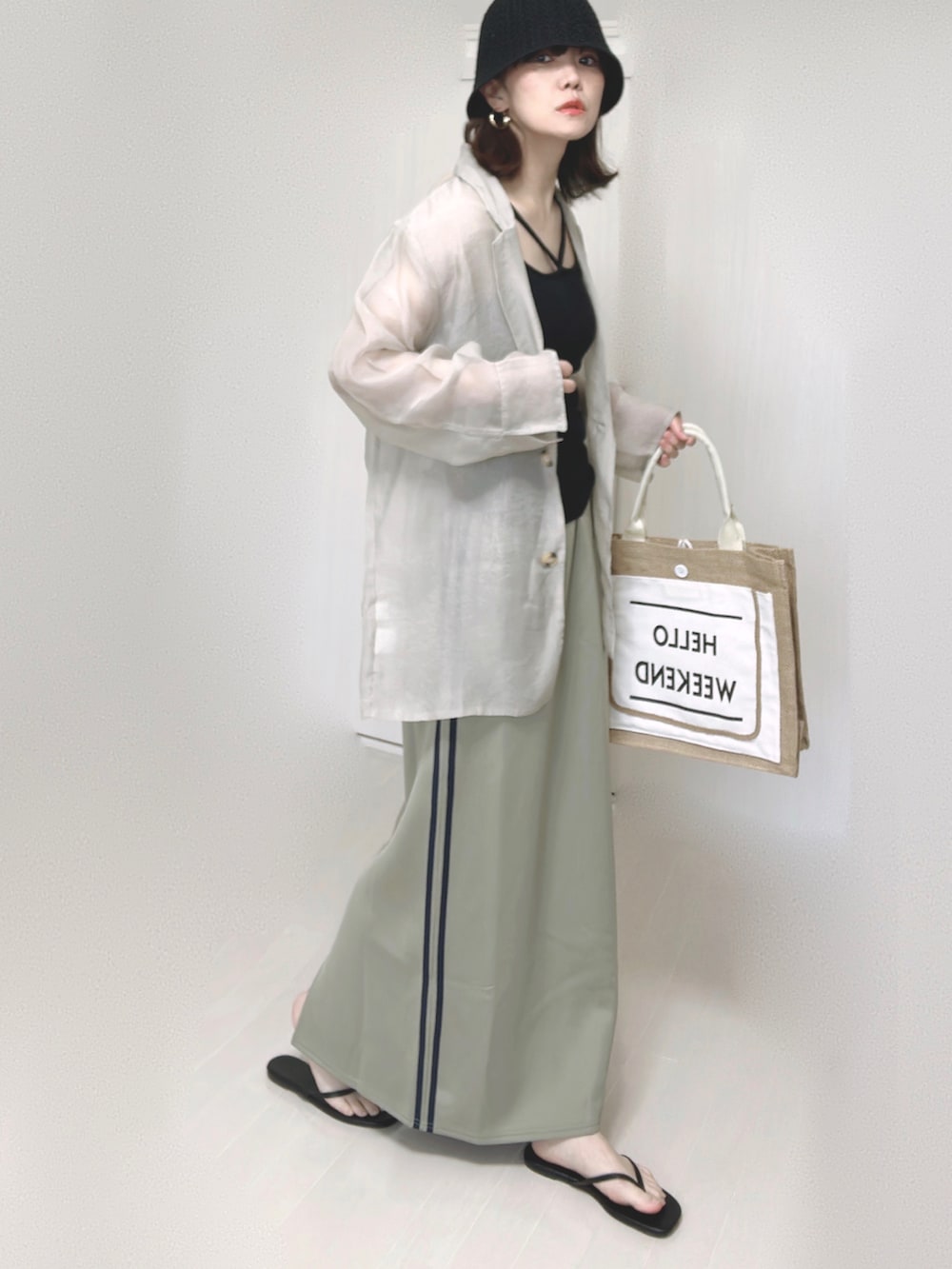 ブルー系のスカート、グレー系のテーラードジャケット、ブラック系のキャミソールを着用したレディースの夏コーディネートの3枚目の写真