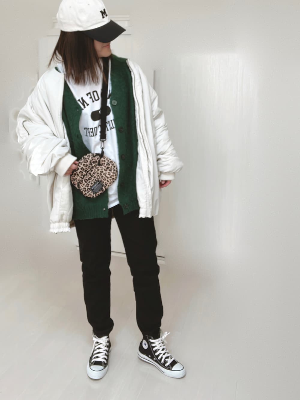 ホワイト系のTシャツ/カットソー、ホワイト系のブルゾン、グリーン系のカーディガン/ボレロを着用したレディースの冬コーディネートの4枚目の写真