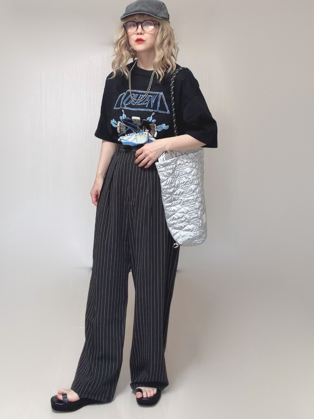 シルバー系のトートバッグ、ブラック系のサンダル、イエロー系のTシャツ/カットソーを着用したレディースの夏コーディネートの3枚目の写真