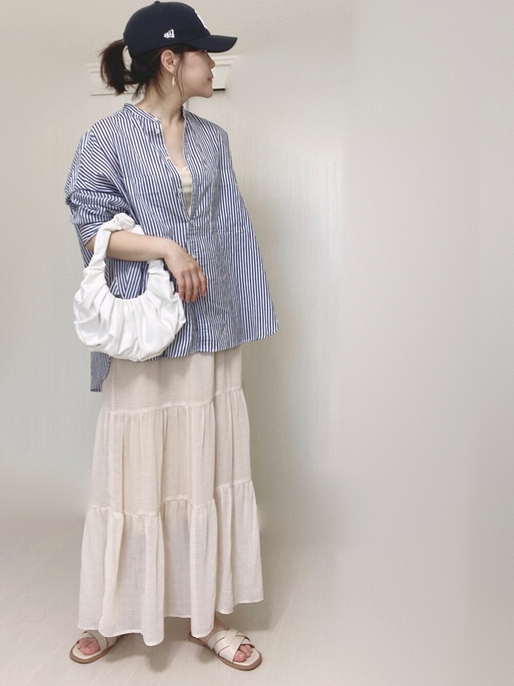 ホワイト系のキャミソール、ホワイト系のスカート、ホワイト系のサンダルを着用したレディースの夏コーディネートの2枚目の写真