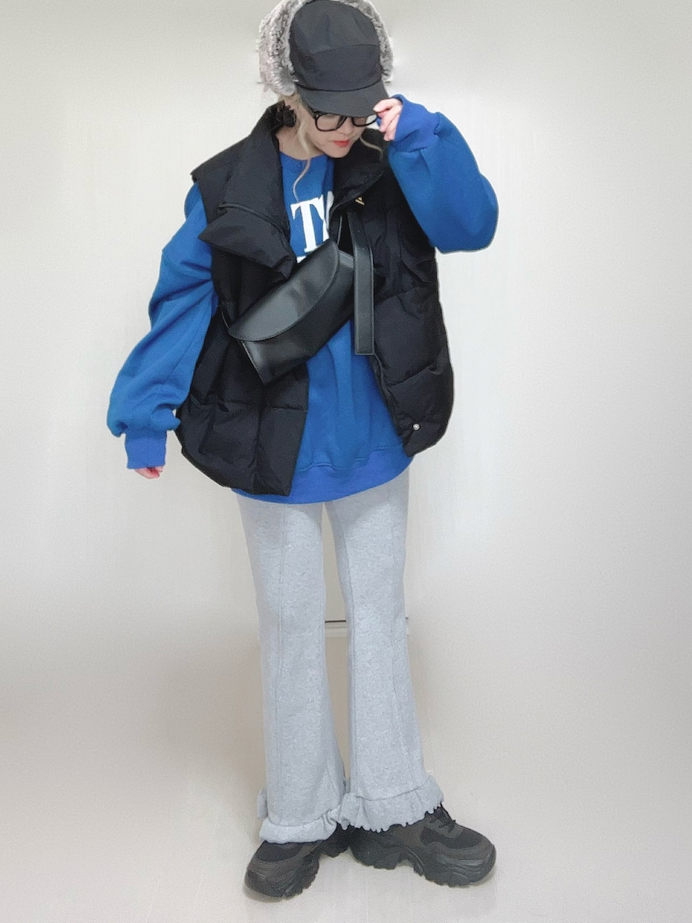 ブラック系のダウンベスト、グレー系のその他パンツ、ブラック系のスニーカーを着用したレディースの秋コーディネートの3枚目の写真