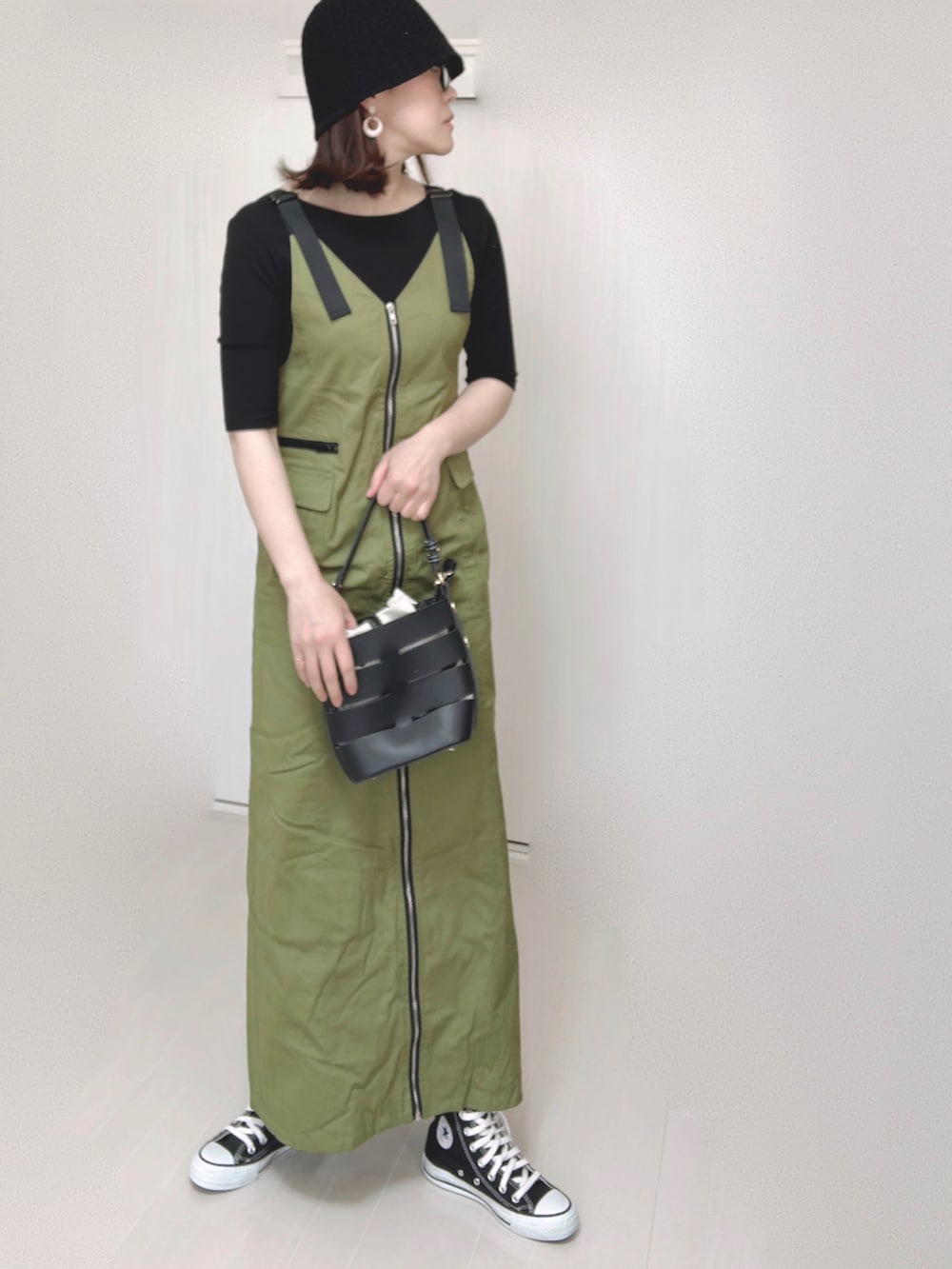 グリーン系のジャンパースカート、ブラック系のTシャツ/カットソー、ブラック系のショルダーバッグを着用したレディースの夏コーディネートの3枚目の写真