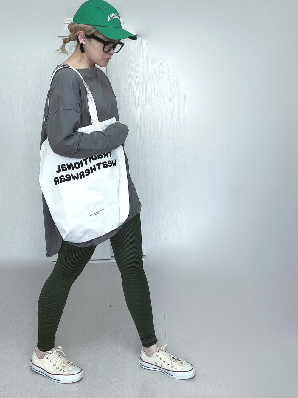 ベージュ系のTシャツ/カットソー、ホワイト系のトートバッグ、ホワイト系のスニーカーを着用したレディースの春コーディネートの2枚目の写真