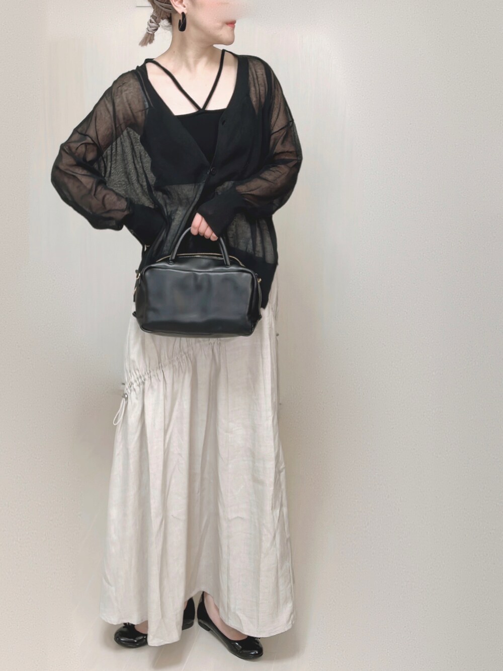 ブラック系のカーディガン/ボレロ、ブラック系のキャミソール、ブラック系のボストンバッグを着用したレディースの夏コーディネートの2枚目の写真