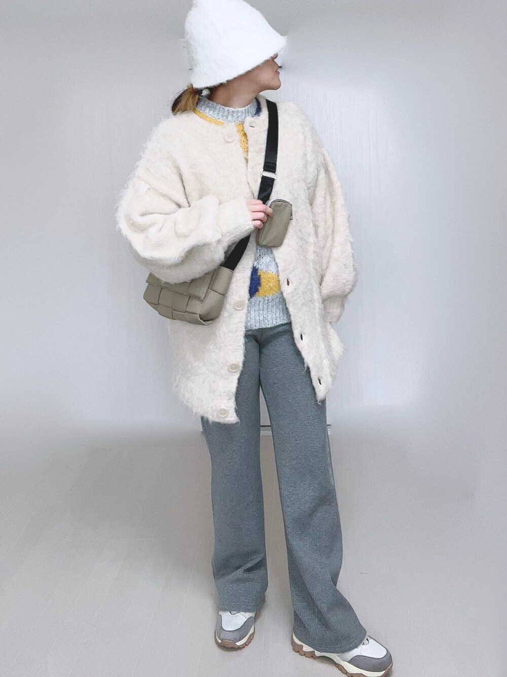ベージュ系のカーディガン/ボレロ、グレー系のその他パンツ、ベージュ系のスニーカーを着用したレディースの冬コーディネートの3枚目の写真