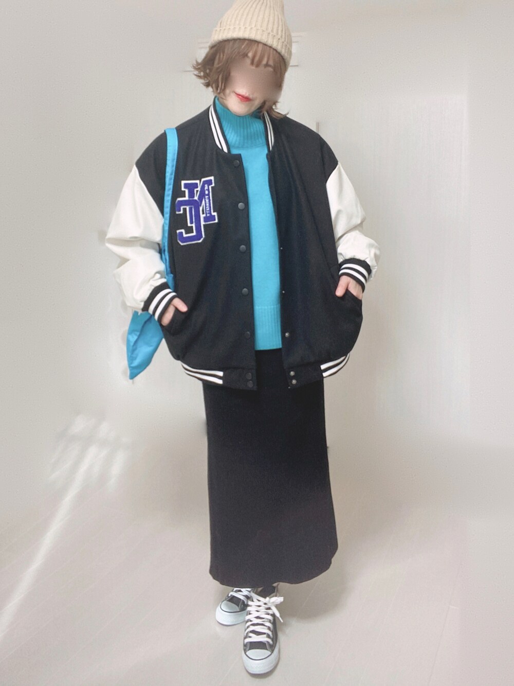 ブルー系のニット/セーター、ブラック系のスタジャン、ブルー系のトートバッグを着用したレディースの冬コーディネートの3枚目の写真