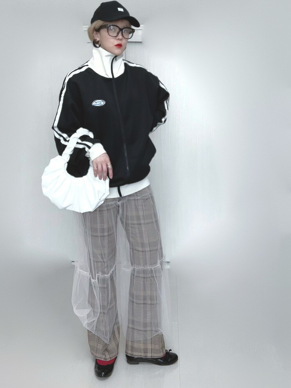 ブラック系のブルゾン、ホワイト系のスカート、ベージュ系のその他パンツを着用したレディースの春コーディネートの4枚目の写真