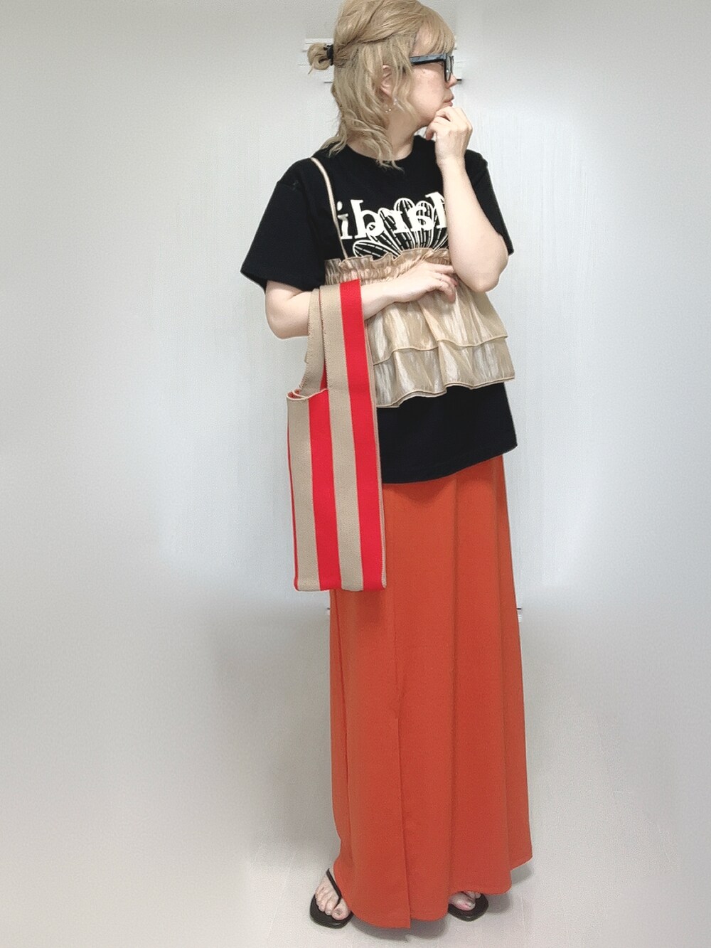 オレンジ系のキャミソール、ブラック系のTシャツ/カットソー、オレンジ系のスカートを着用したレディースの夏コーディネートの5枚目の写真