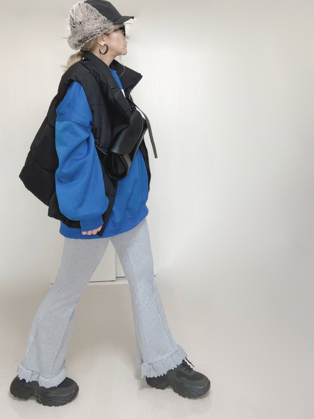 ブラック系のダウンベスト、グレー系のその他パンツ、ブラック系のスニーカーを着用したレディースの秋コーディネートの5枚目の写真