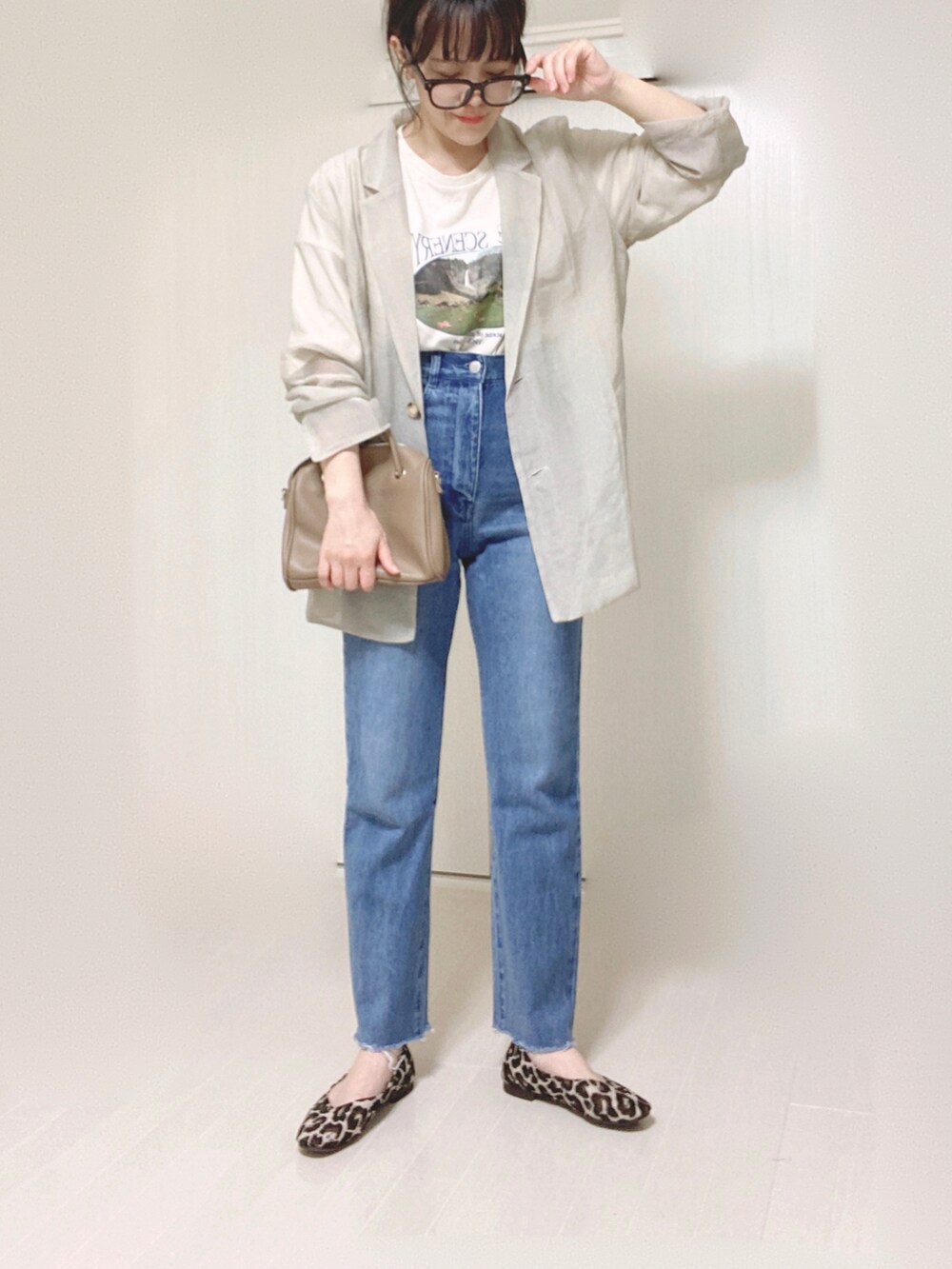 グレー系のテーラードジャケット、ホワイト系のTシャツ/カットソー、ブルー系のデニムパンツを着用したレディースの夏コーディネートの4枚目の写真