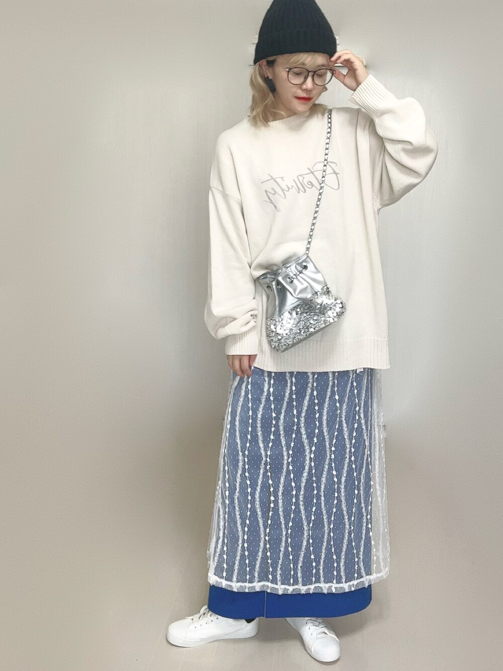 ホワイト系のニット/セーター、シルバー系のショルダーバッグ、ホワイト系のスカートを着用したレディースの秋コーディネートの4枚目の写真