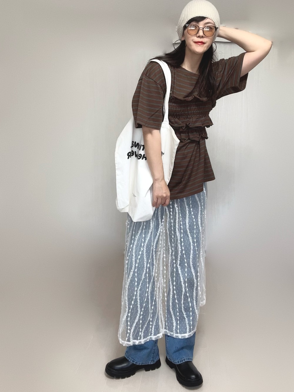 ブラウン系のTシャツ/カットソー、ブルー系のデニムパンツ、ホワイト系のスカートを着用したレディースの夏コーディネートの5枚目の写真