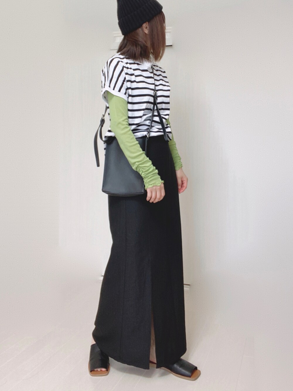 ホワイト系のTシャツ/カットソー、ブラック系のスカート、ホワイト系のスニーカーを着用したレディースの夏コーディネートの2枚目の写真