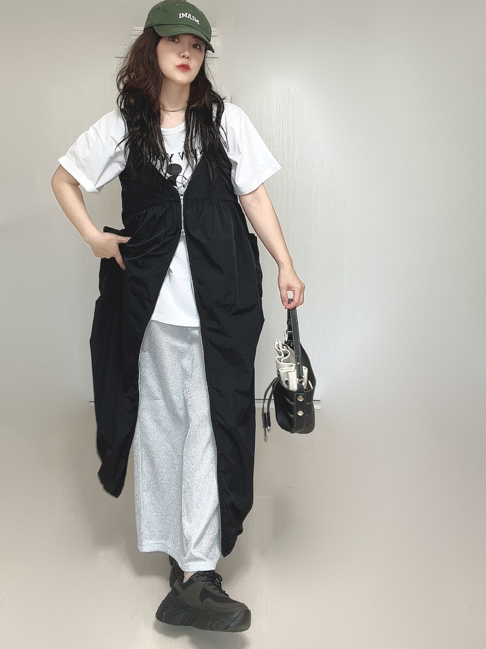 ブラック系のワンピース、ホワイト系のTシャツ/カットソー、ブラック系のショルダーバッグを着用したレディースの夏コーディネートの5枚目の写真