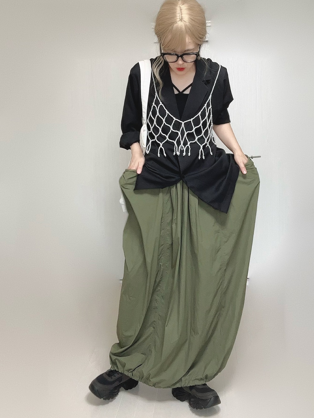 ブラック系のテーラードジャケット、ブラック系のキャミソール、ホワイト系のベストを着用したレディースの夏コーディネートの4枚目の写真