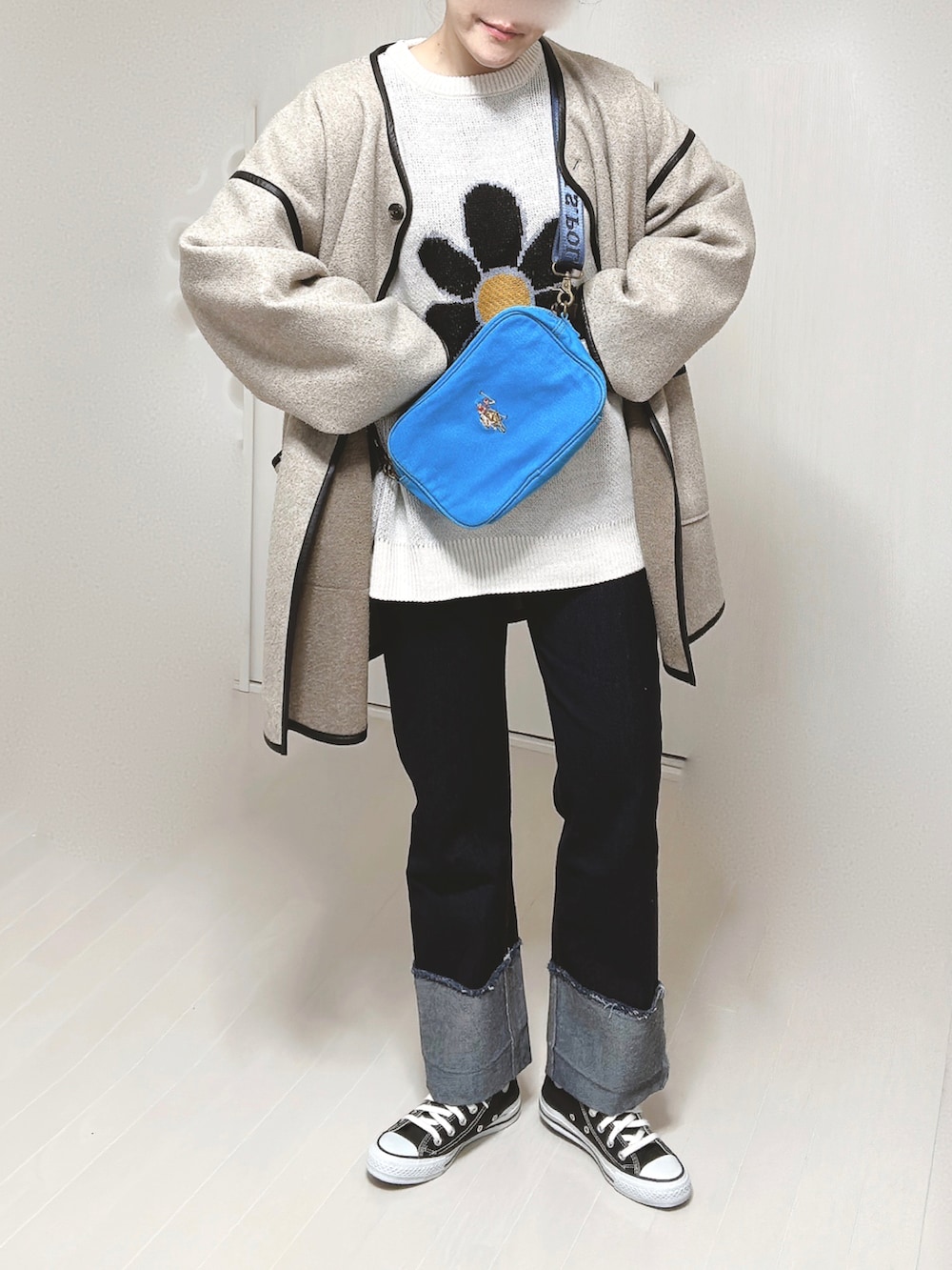 ブルー系のショルダーバッグ、ホワイト系のニット/セーター、ベージュ系のその他アウターを着用したレディースの冬コーディネートの4枚目の写真