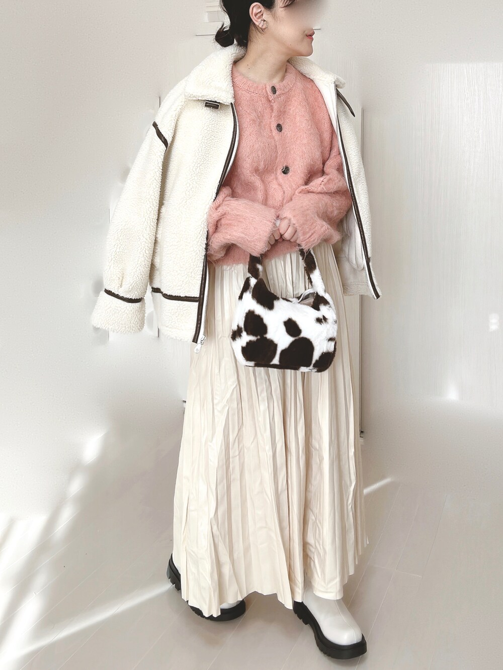 ピンク系のカーディガン/ボレロ、ホワイト系のブルゾン、ホワイト系のスカートを着用したレディースの冬コーディネートの3枚目の写真