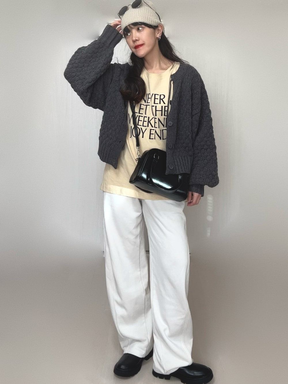 グレー系のニット/セーター、ブラック系のブーツ、ベージュ系のTシャツ/カットソーを着用したレディースの冬コーディネートの3枚目の写真