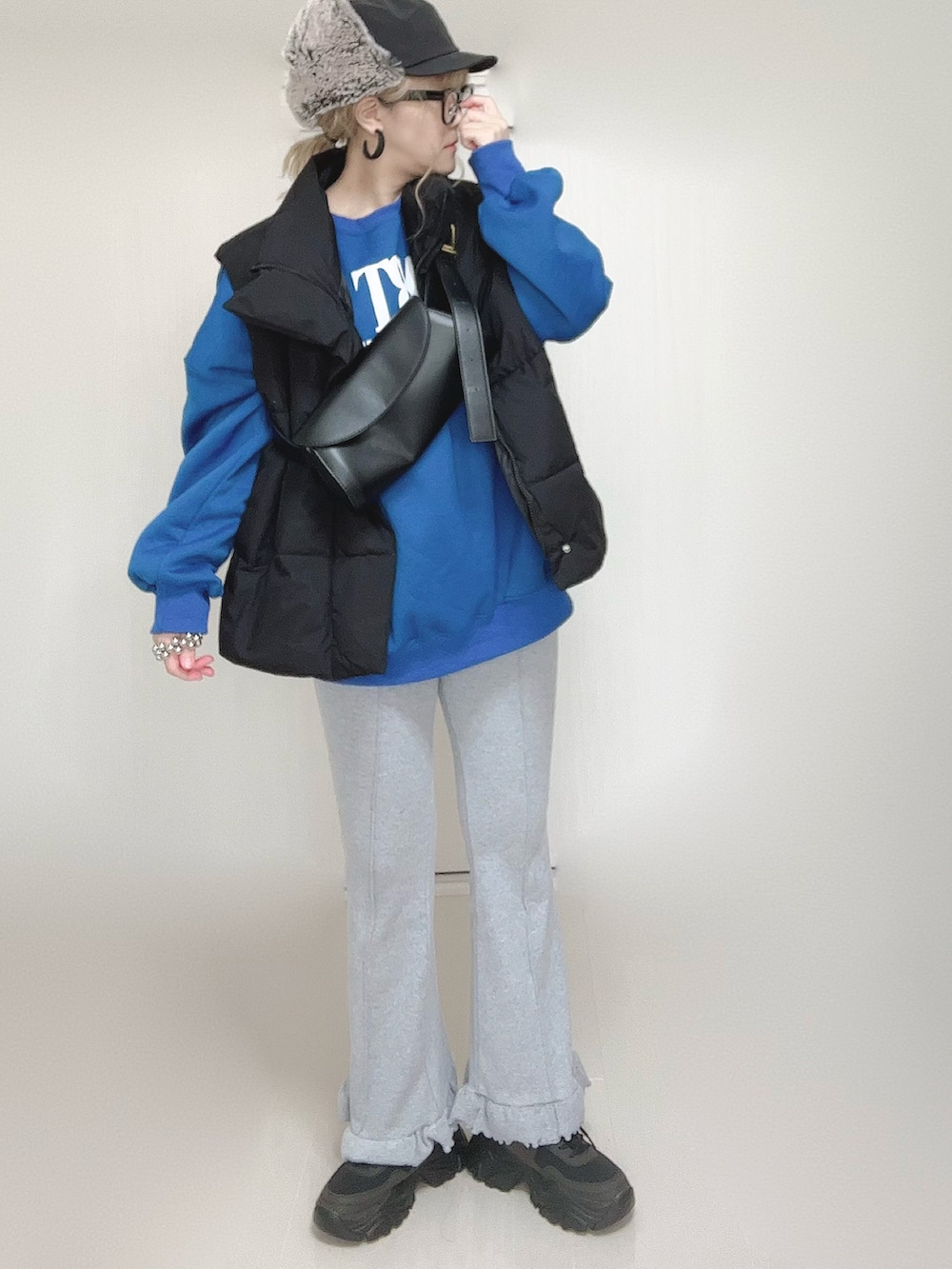 ブラック系のダウンベスト、グレー系のその他パンツ、ブラック系のスニーカーを着用したレディースの秋コーディネートの4枚目の写真