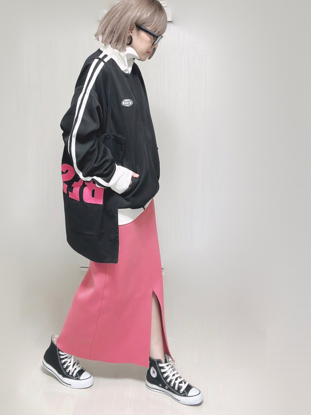 ブラック系のブルゾン、ブラック系のトートバッグ、ピンク系のスカートを着用したレディースの秋コーディネートの3枚目の写真