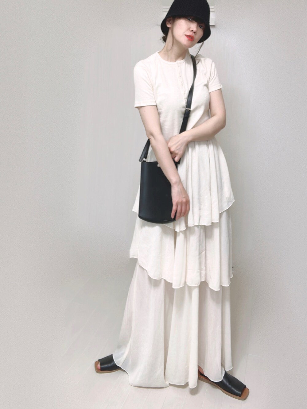 ホワイト系のTシャツ/カットソー、ブラック系のショルダーバッグ、ホワイト系のスカートを着用したレディースの夏コーディネートの4枚目の写真
