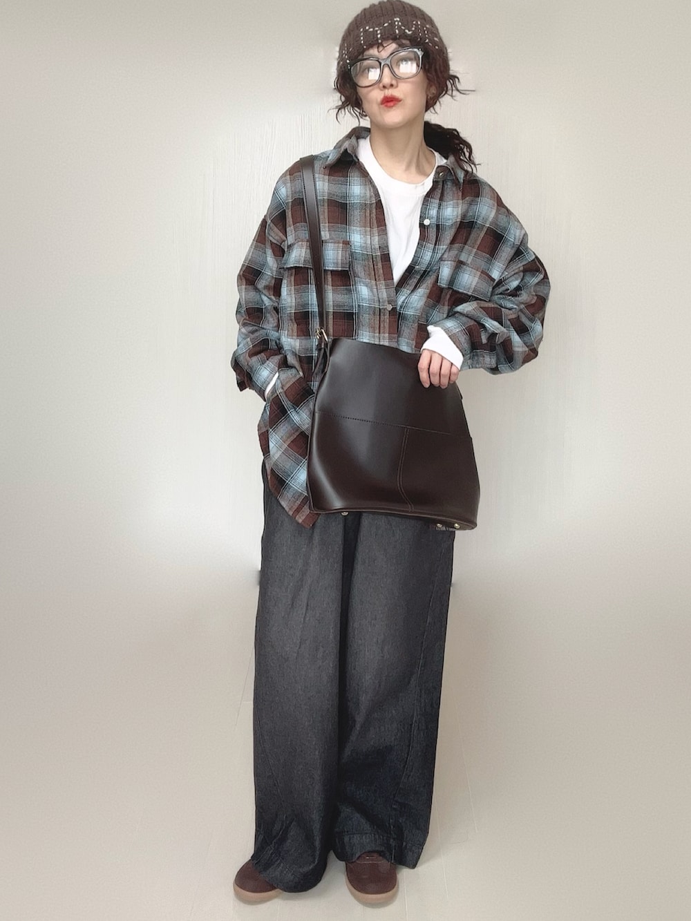 ブラウン系のシャツ/ブラウス、ホワイト系のTシャツ/カットソー、ブラック系のデニムパンツを着用したレディースの冬コーディネートの2枚目の写真