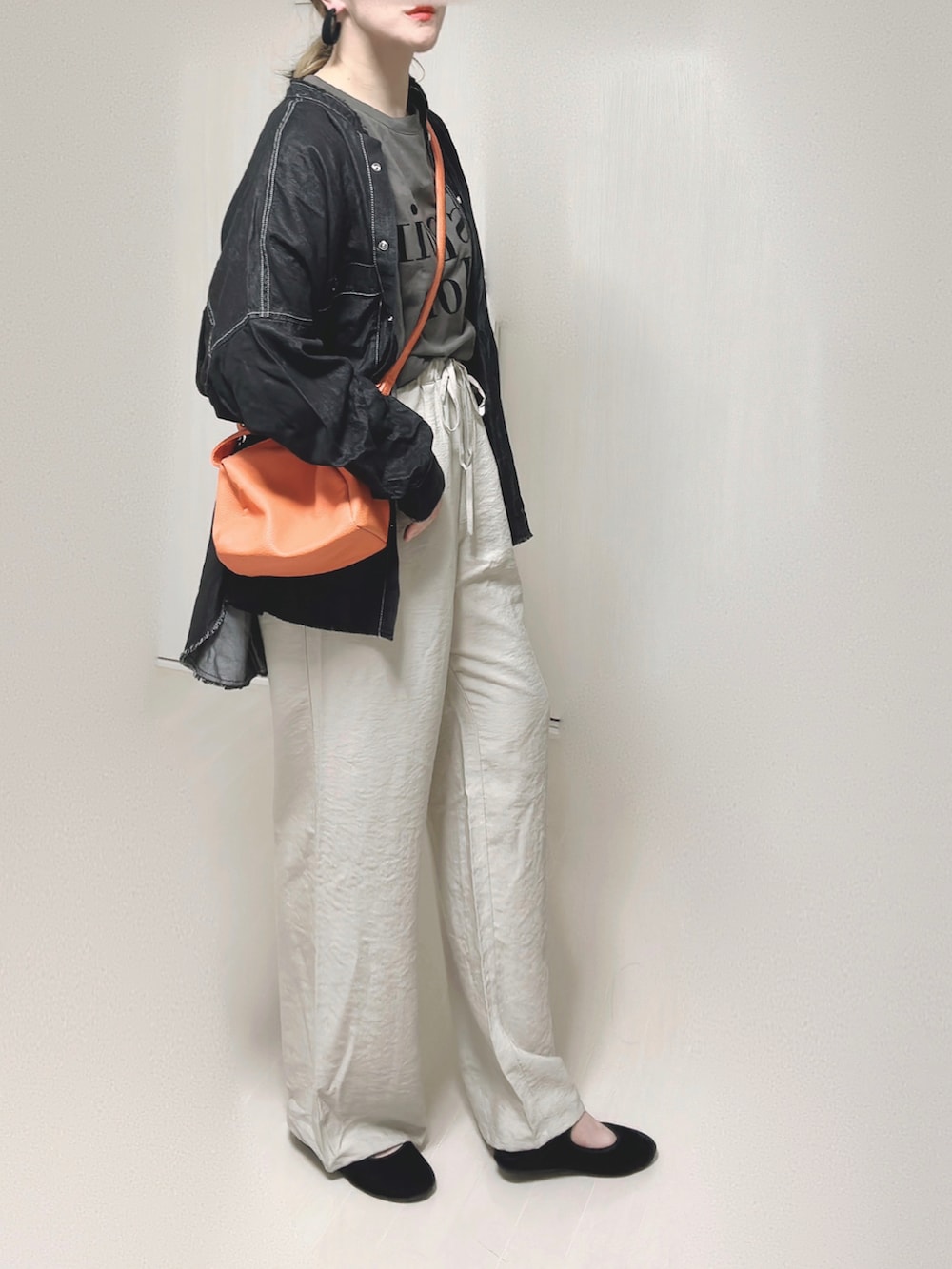 ブラック系のシャツ/ブラウス、オレンジ系のショルダーバッグ、ブラック系のパンプスを着用したレディースの秋コーディネートの3枚目の写真