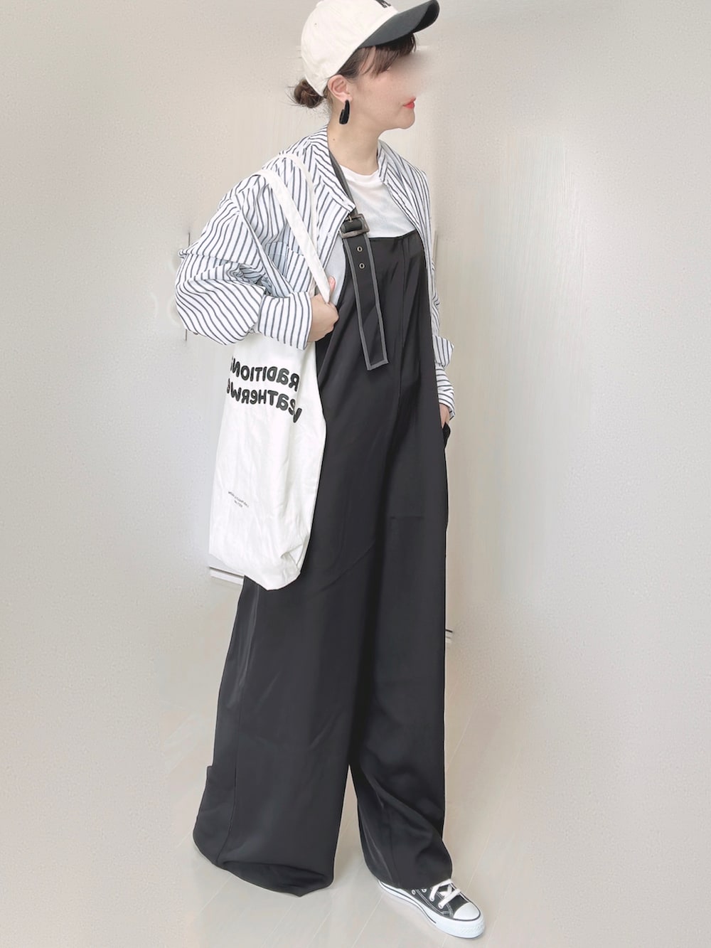 ブラック系のサロペット/オーバーオール、ホワイト系のTシャツ/カットソー、ホワイト系のシャツ/ブラウスを着用したレディースの秋コーディネートの2枚目の写真