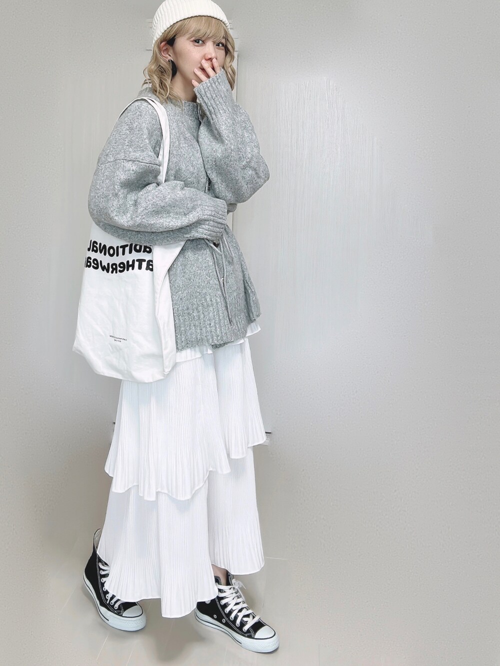 ホワイト系のスカート、ホワイト系のトートバッグ、ブラック系のスニーカーを着用したレディースの秋コーディネートの3枚目の写真