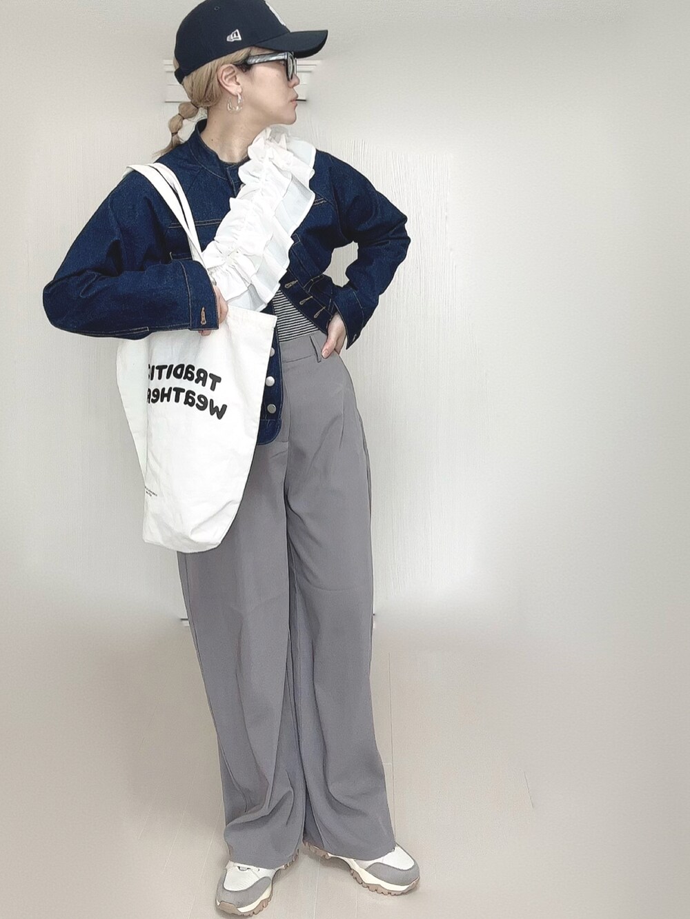 ブルー系のデニムジャケット、グレー系のその他パンツ、ホワイト系のトートバッグを着用したレディースの春コーディネートの3枚目の写真