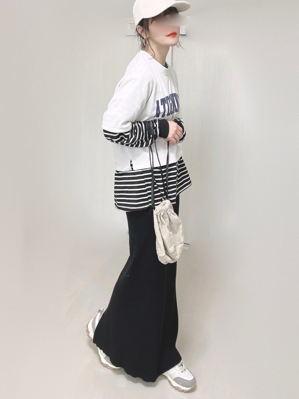 ホワイト系のTシャツ/カットソー、ベージュ系のハンドバッグ、ブラック系のスカートを着用したレディースの春コーディネートの3枚目の写真