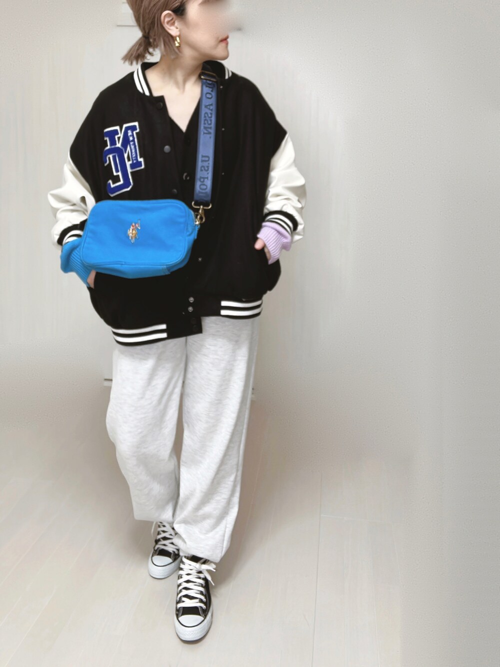 ブルー系のショルダーバッグ、ブラック系のスタジャン、ブラック系のカーディガン/ボレロを着用したレディースの春コーディネートの3枚目の写真