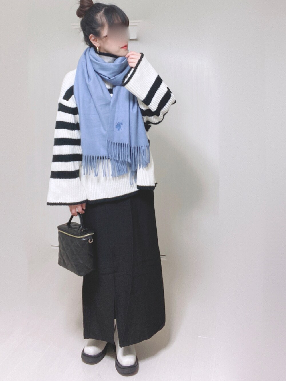 ホワイト系のニット/セーター、ブラック系のスカート、ホワイト系のブーツを着用したレディースの秋コーディネートの3枚目の写真