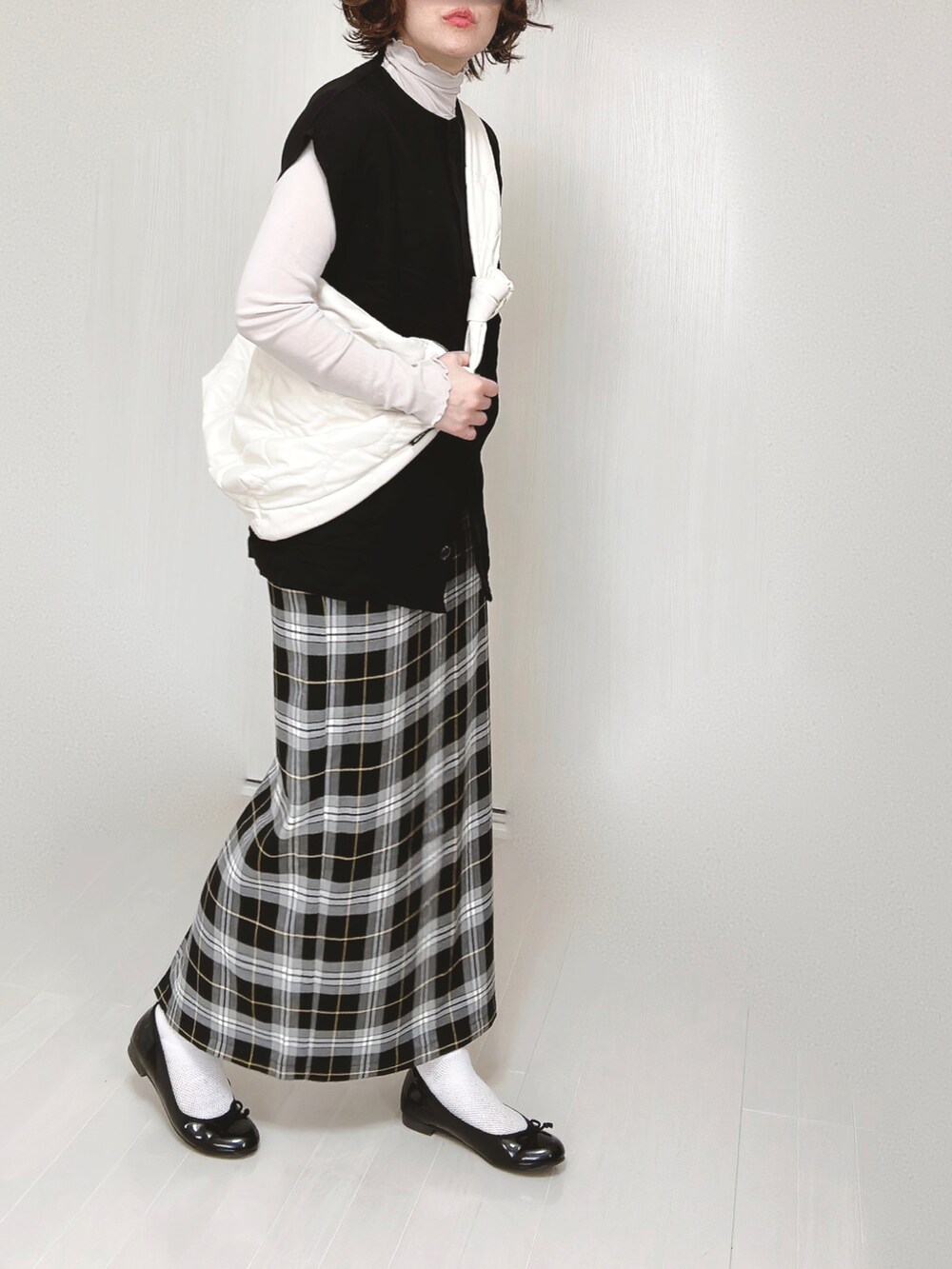 ブラック系のベスト、グレー系のTシャツ/カットソー、ホワイト系のショルダーバッグを着用したレディースの春コーディネートの5枚目の写真