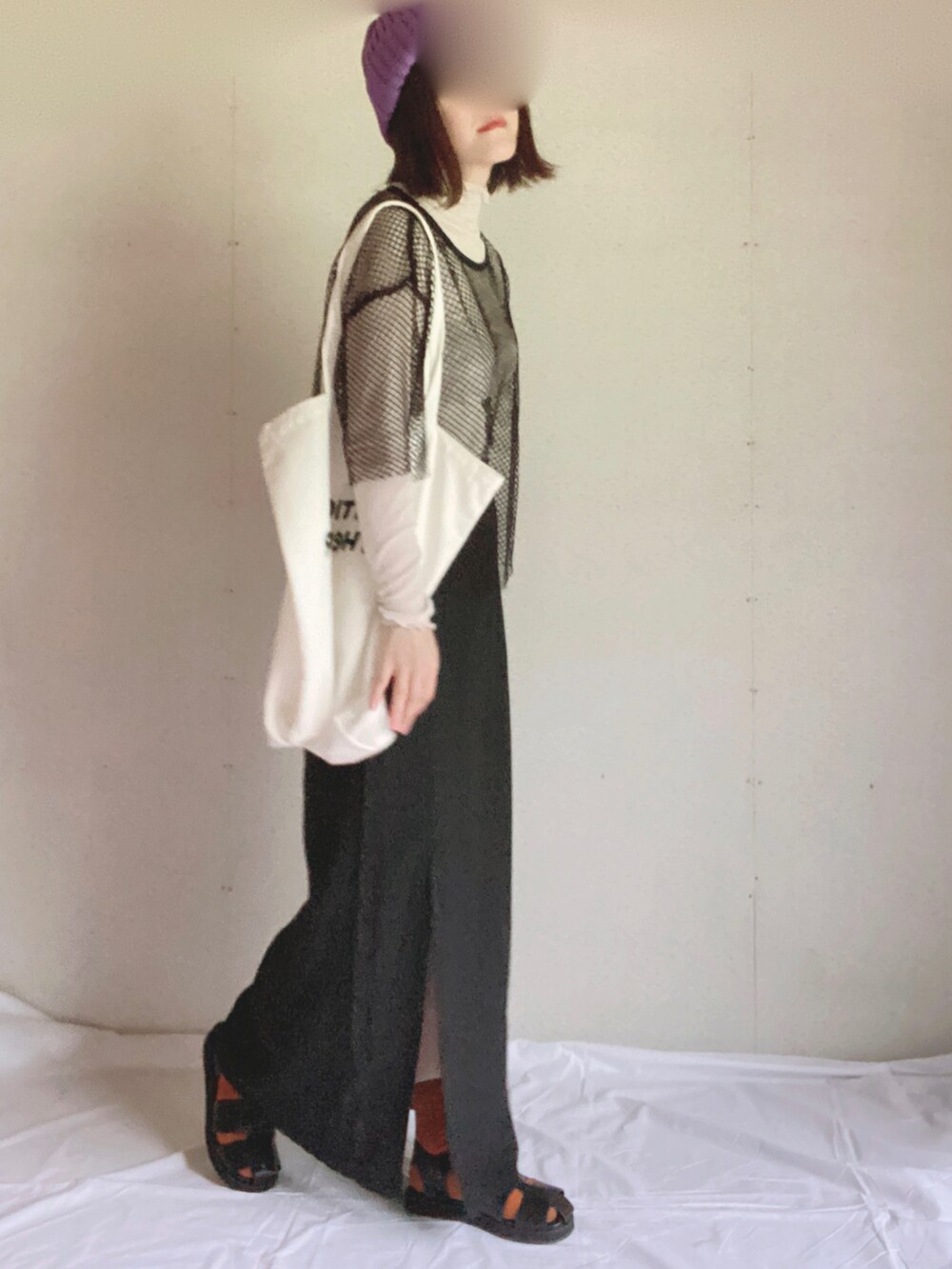 ブラック系のスカート、グレー系のTシャツ/カットソー、ホワイト系のトートバッグを着用したレディースの夏コーディネートの2枚目の写真