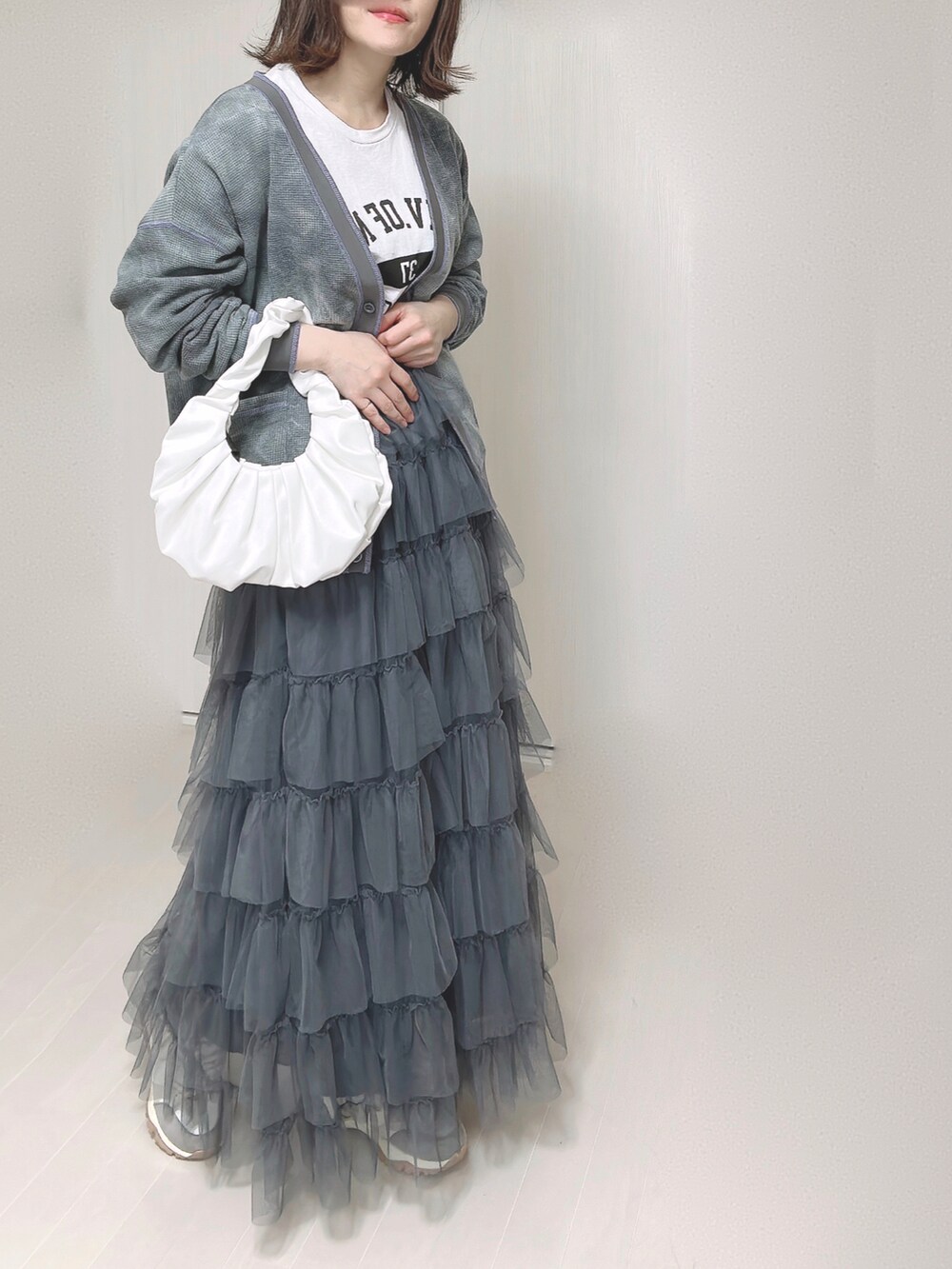 ブラック系のカーディガン/ボレロ、ホワイト系のTシャツ/カットソー、グレー系のスカートを着用したレディースの春コーディネートの3枚目の写真