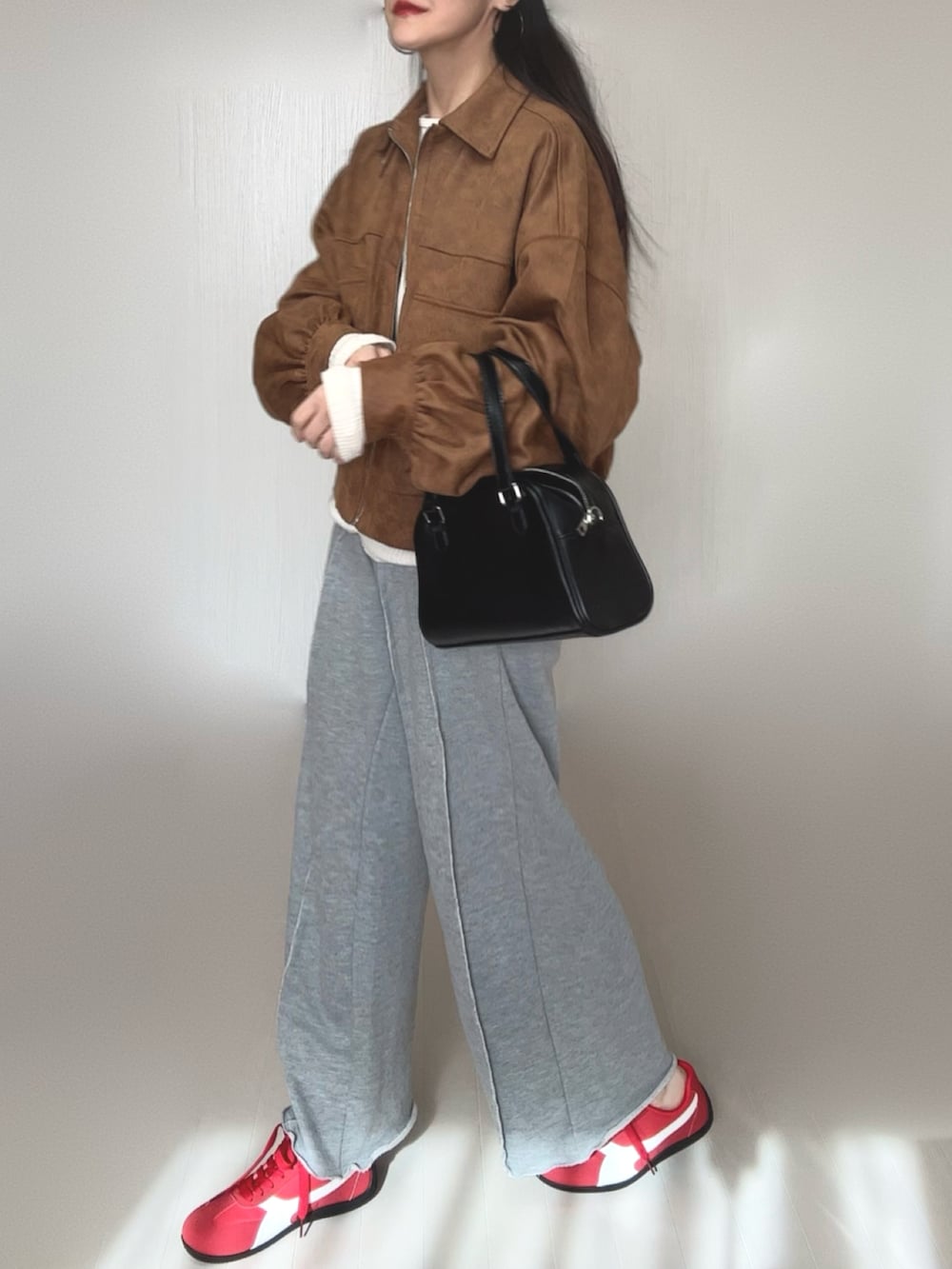 ベージュ系のブルゾン、グレー系のスウェットパンツ、ベージュ系のTシャツ/カットソーを着用したレディースの冬コーディネートの4枚目の写真