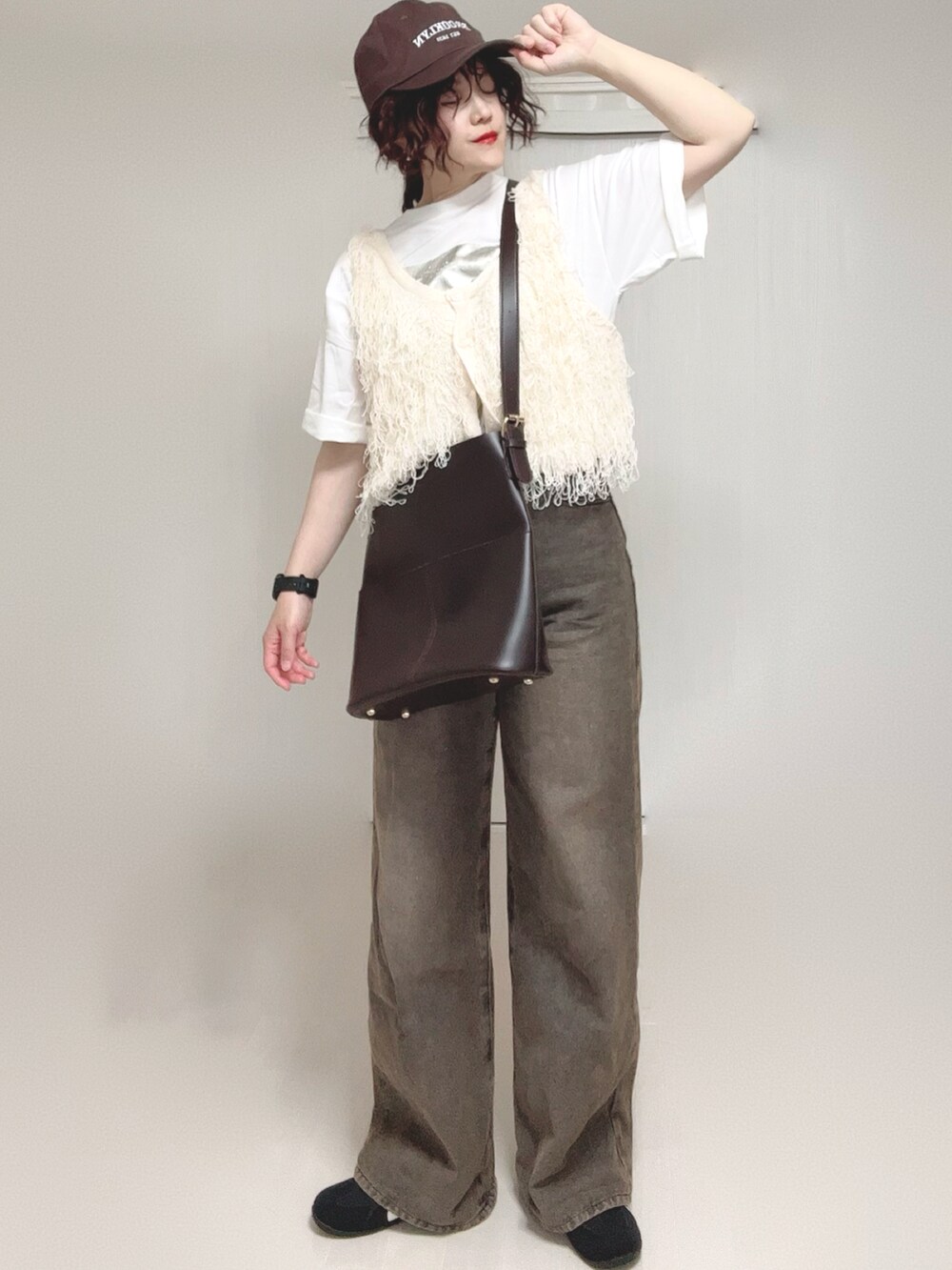ホワイト系のベスト、ホワイト系のTシャツ/カットソー、ブラック系のデニムパンツを着用したレディースの夏コーディネートの4枚目の写真