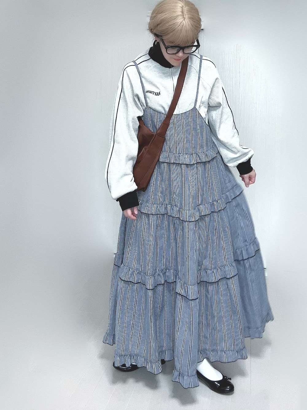 ベージュ系のジャージ、ブラック系のワンピース、ブラック系のバレエシューズを着用したレディースの春コーディネートの3枚目の写真